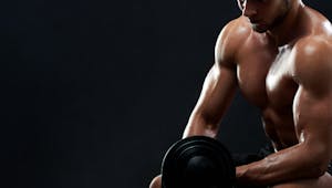Muscular young man lifting weights